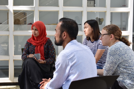 Multi-faith students seated in a group, listening to a speaker